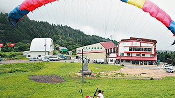 Un edificio con fachada roja y blanca, techo verde y cartelera blanca.