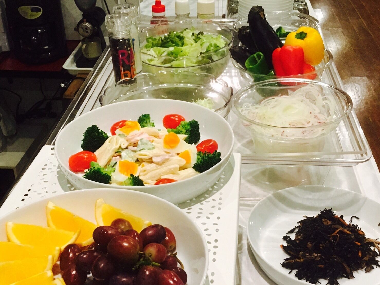 Una mesa de buffet con diversos alimentos, como ensaladas, frutas y verduras.