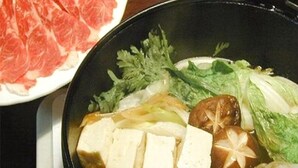 Eine Schüssel mit Tofu, Pilzen und Blattgemüse.