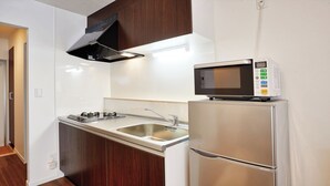 A modern kitchen with a built-in microwave, stainless steel appliances, and a sleek design. - Condominium Yuyuki (Yomitan)