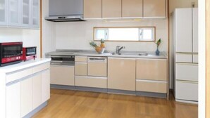 A modern kitchen with a microwave, stove, sink, and cabinets. - Palm Villa Ishigakijima Igusa (Ishigaki)