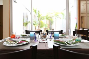 A dining table set for four with candles, glasses, and cutlery. - Palm Villa Ishigakijima Igusa (Ishigaki)