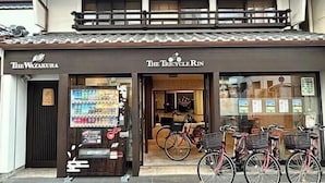 A storefront with a sign reading "The Tricycle Rin" and another sign for "The Wazakura." - Guesthouse Wazakura (Sakurai)