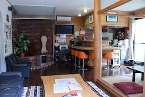 Un salon chaleureux avec une cheminée, des fauteuils et un coin repas agrémenté d’un bar.