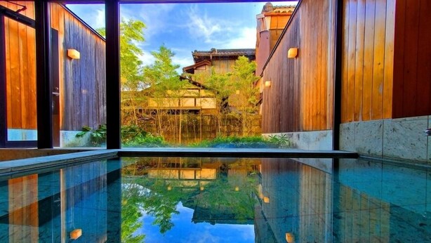 A modern interior with a reflective pool, wooden walls, and a traditional building in the background. - Tochigi Grand Hotel (Tochigi)