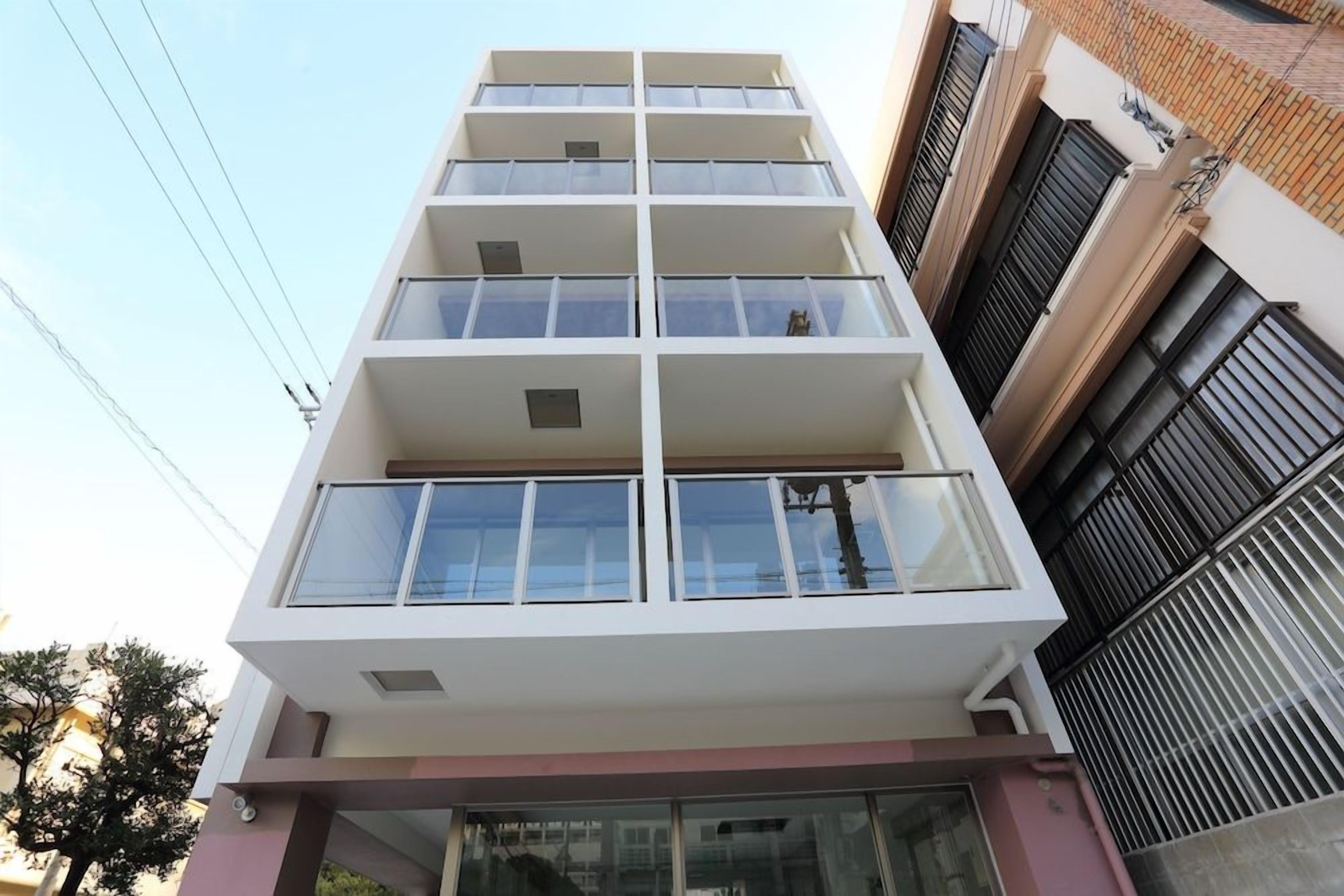 A multi-story building with balconies, large windows, and a flat facade.