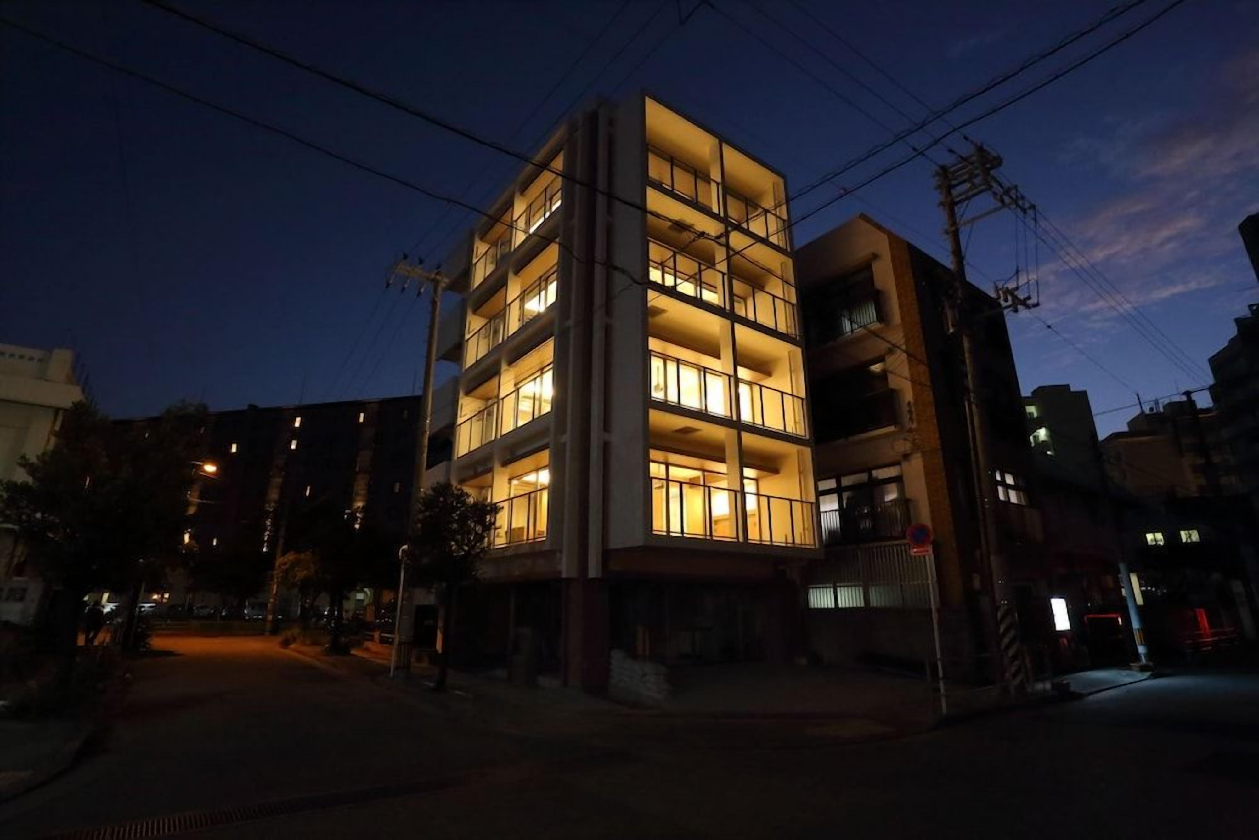 A multi-story building with illuminated windows at night.