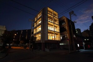 A multi-story building with illuminated windows at night.