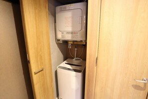 Ein kleiner, abgeschlossener Waschraum mit Waschmaschine und Trockner.