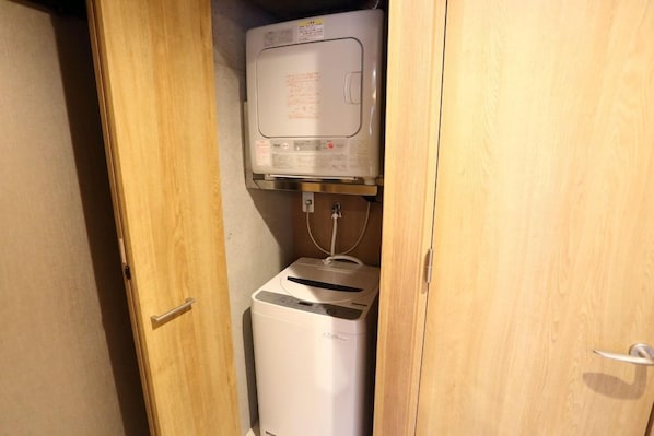 Ein kleiner, abgeschlossener Waschraum mit Waschmaschine und Trockner.