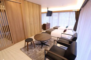 Une chambre d’hôtel avec un lit, un bureau, une chaise, une télévision et une fenêtre avec des rideaux.