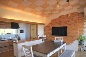 Una cocina moderna con una isla de madera, armarios blancos y un microondas integrado.