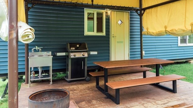An outdoor patio with a grill, a table, and a barrel. - Pica Fuji Grinpa (Susono)