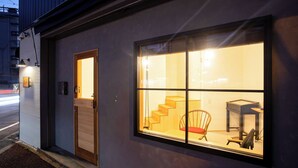 A modern building with a large window, a wooden door, and a staircase leading to an upper level. - Life Style Hotel Ichi (Kochi)