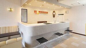 A reception area with a counter, seating, and a clock. - Sasebo Daiichi Hotel (Sasebo)
