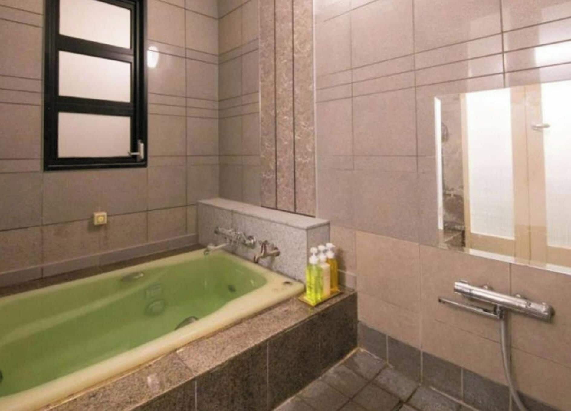 Une salle de bain avec une baignoire, un lavabo et un miroir.