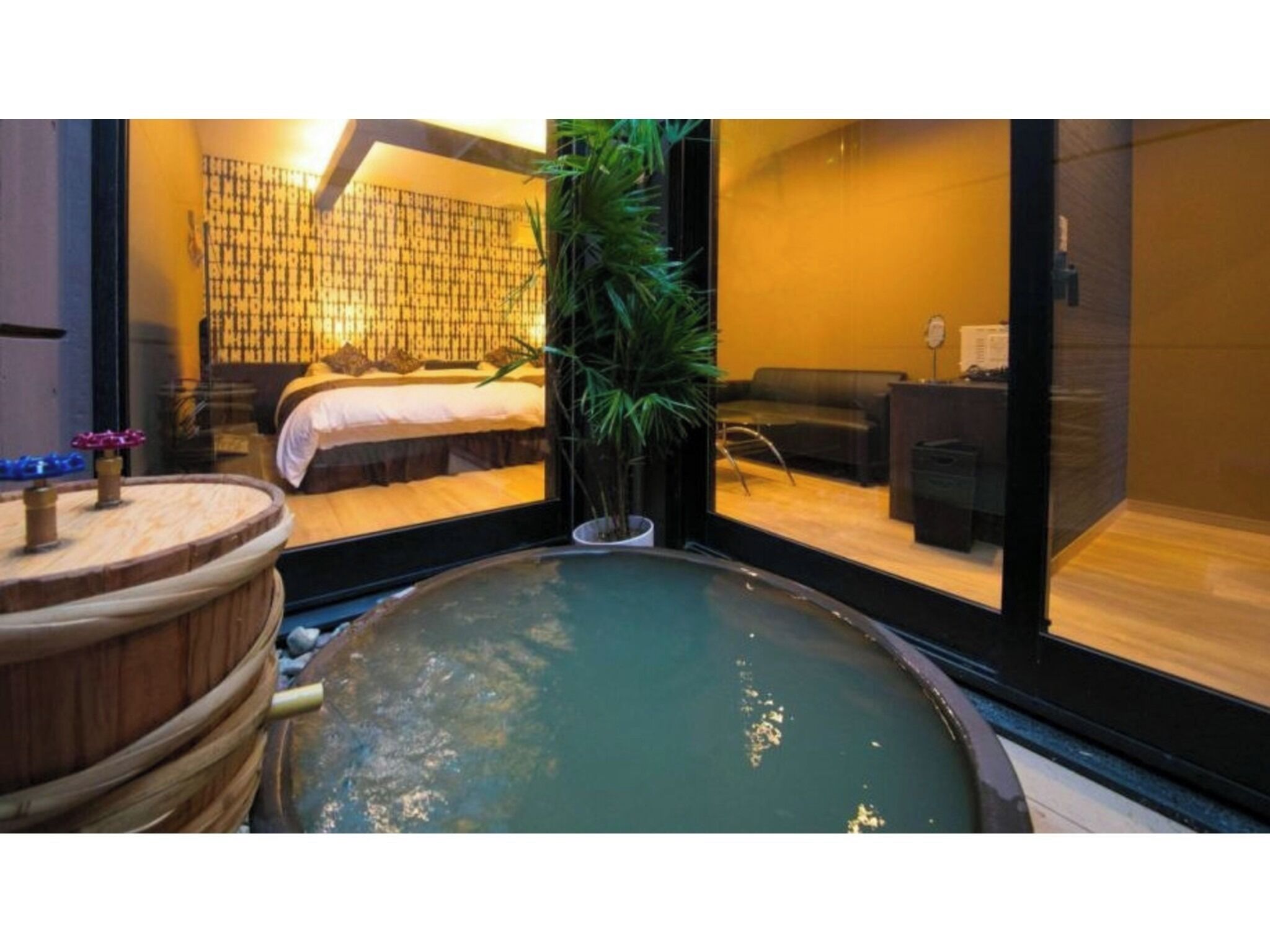 A spa room with a hot tub, a bed, and a large window.