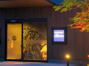A hotel entrance with a glass door, a signboard, and a street lamp. - Oita Onsen Business Resort Sourin (Oita)