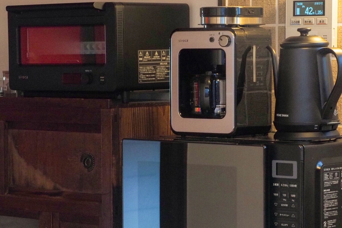 Une cuisine équipée d’un four à micro-ondes, d’une machine à café et d’un placard.