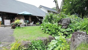 A building with a green awning, outdoor seating, and a signboard. - Tabi-yado Bunsuirei (Gujo)