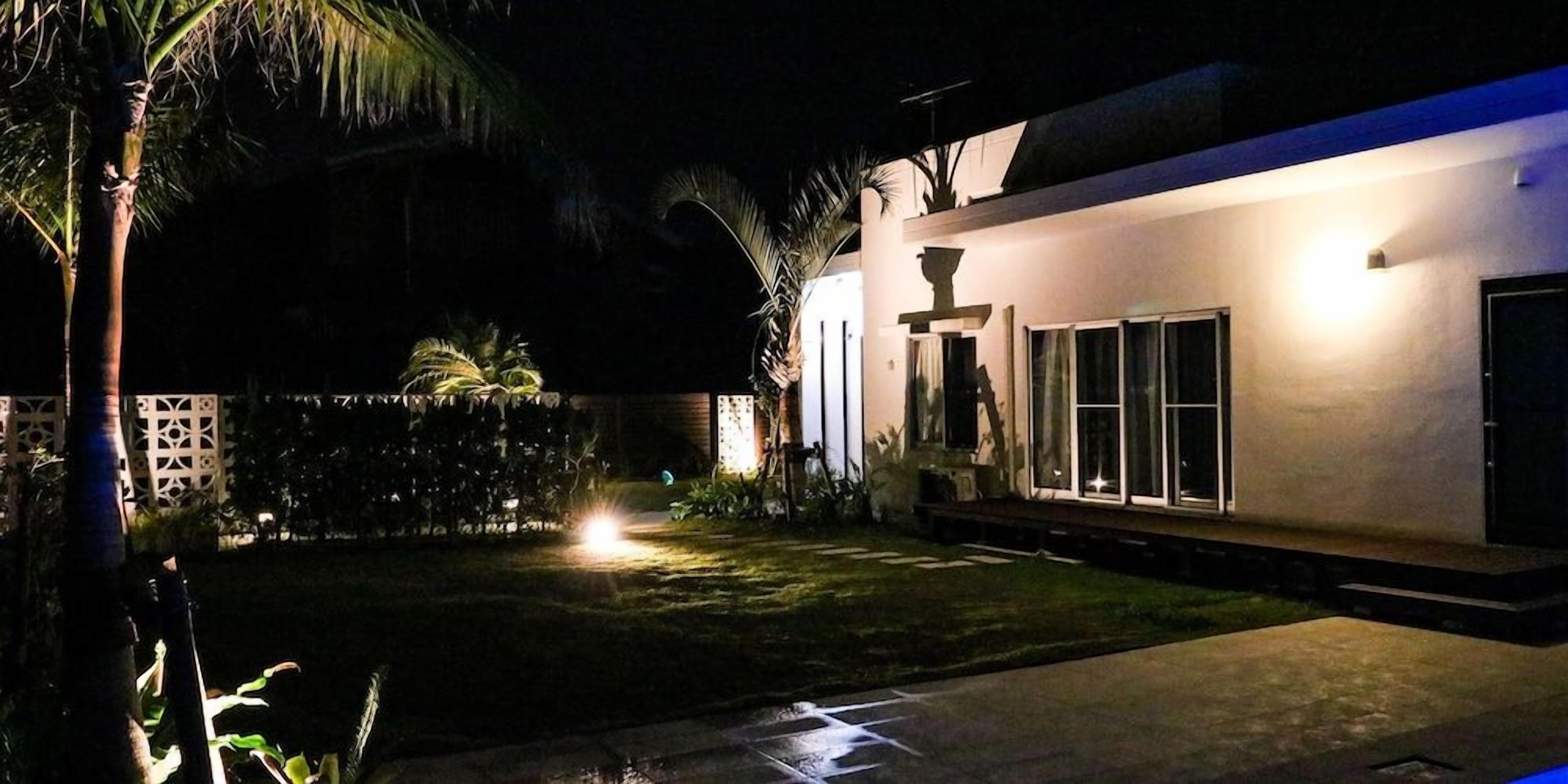 A nighttime view of a building with a well-lit entrance and a paved courtyard.