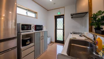 A compact kitchen with a refrigerator, microwave, and stove.