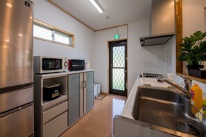 Cocina pequeña equipada con refrigerador, microondas y estufa.