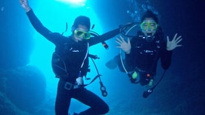 Two divers underwater with a light source above them. - United Resort Kibogaoka (Onna)