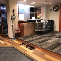 A shoe cleaning station with a shoe rack, a counter with a clock, and a display case with shoes.