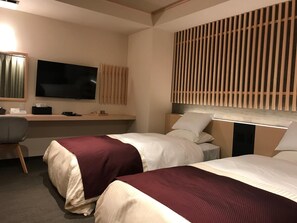 A hotel room with two beds, a desk, a television, and a wall-mounted panel. - Aizu Tsuruya Hotel (Aizuwakamatsu)