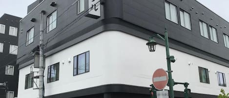 A building with a white and black facade, a no entry sign, and a street lamp.