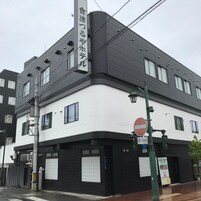 A building with a white and black facade, a no entry sign, and a street lamp.