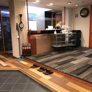 A shoe store interior with wooden flooring, a shoe display counter, and a clock on the wall. - Aizu Tsuruya Hotel (Aizuwakamatsu)