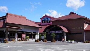 A building with a prominent 'GRAND OPEN' sign, featuring a modern architectural style with a red roof and a large arched entrance. - Niimi Chiya Onsen Ibuki no Sato (Niimi)