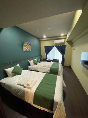 A hotel room with two beds, a painting on the wall, and a window with curtains. - Hotel Fit In Miyakojima (Miyakojima)