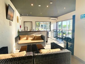 A hotel lobby with a sofa, chairs, a bar area, and a large window offering a view. - Hotel Fit In Miyakojima (Miyakojima)