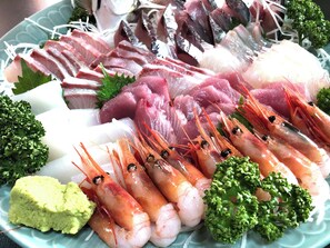 Une variété de fruits de mer, notamment des crevettes et du poisson, et peut-être d’autres types de fruits de mer, présentés sur une assiette.