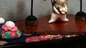 A shelf with various decorative items including a white bear figurine, a colorful fabric doll, and two bird-shaped ornaments. - Umi no Yado Sahei (Minamiechizen)