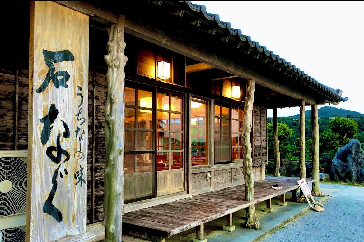 A traditional wooden building with large windows and a wooden deck.