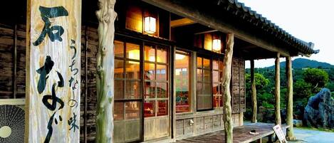 A traditional wooden building with large windows and a wooden deck.