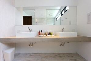 A modern bathroom with two sinks, a large mirror, and a wooden countertop. - The Stella Hamahiga (Uruma)