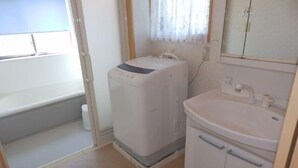 A compact bathroom with a washing machine, a sink, and a window with curtains. - Smith no Ie Chosei (Chosei)