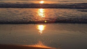 A sunset over a beach with waves reflecting the sun. - Smith no Ie Chosei (Chosei)