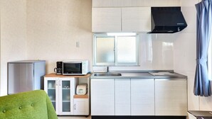 A compact kitchen with a microwave, toaster, and refrigerator. - Rainbow Terrace (Ginowan)