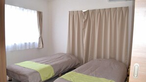 A room with two beds, a window with curtains, and an air conditioning unit. - Rainbow Terrace (Ginowan)