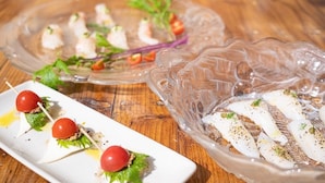 Een houten tafel met twee glazen schalen met eten.