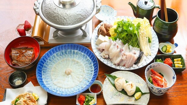 A traditional Japanese meal setup with various dishes, including sushi, sashimi, and a hot pot. - Pension Mangame (Awaji)