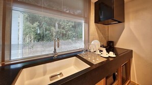 Eine moderne Küche mit großem Fenster, integriertem Spülbecken und einer Kaffeemaschine.