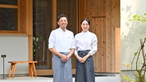 Two individuals standing in front of a wooden wall with the name 'Hashimotoya' visible. - Hashimotoya (Himi)
