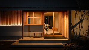 A modern building with a wooden facade, a visible entrance, and a small outdoor seating area. - Hashimotoya (Himi)
